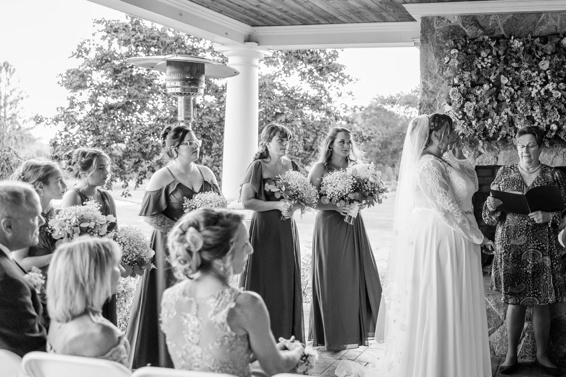 Bride wipes tear while bridesmaids stand beside her during ceremony at Great Neck Country Club Wedding