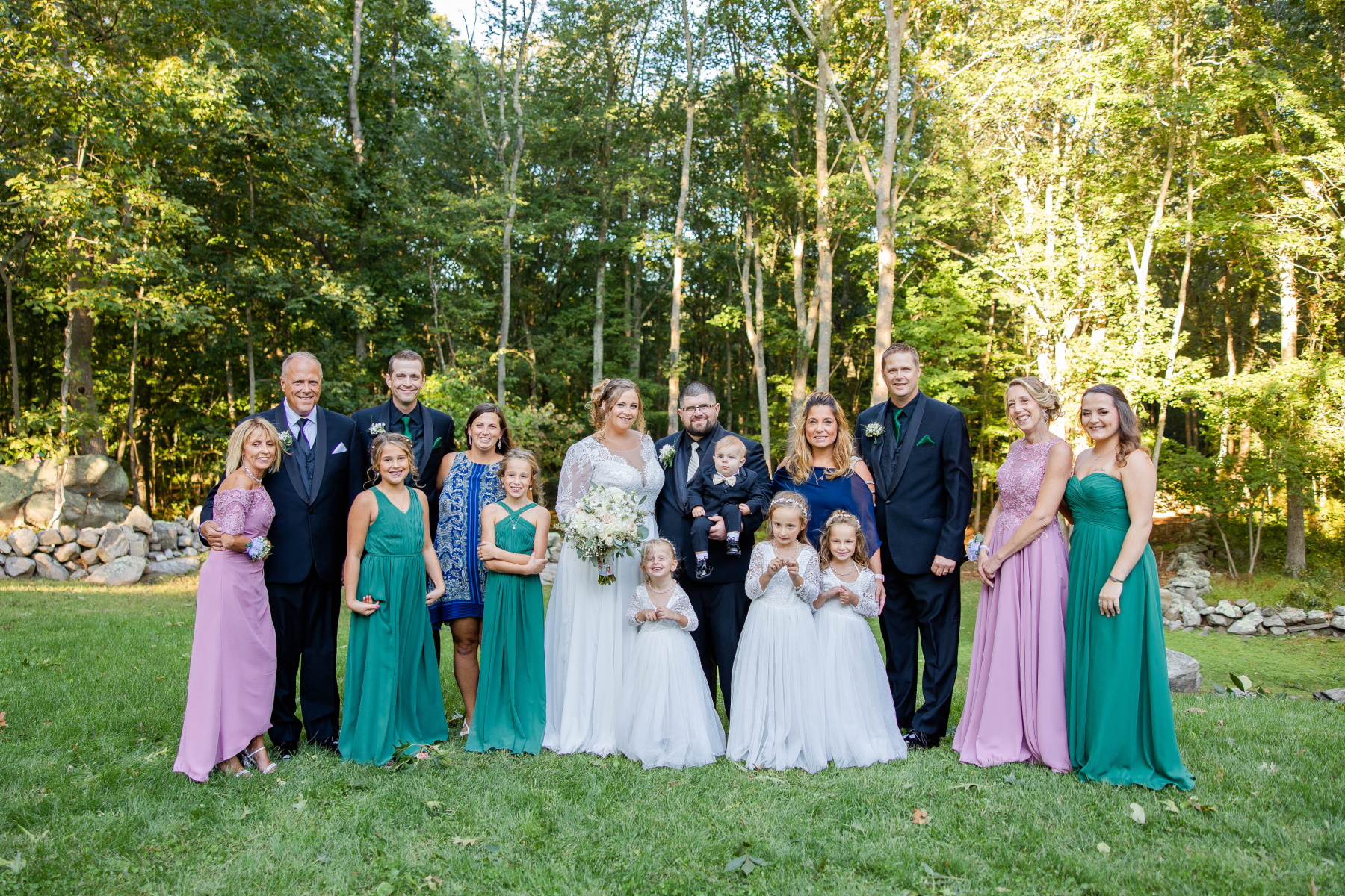Bride and groom smile at camera surrounded with bride's family at Great Neck Country Club Wedding
