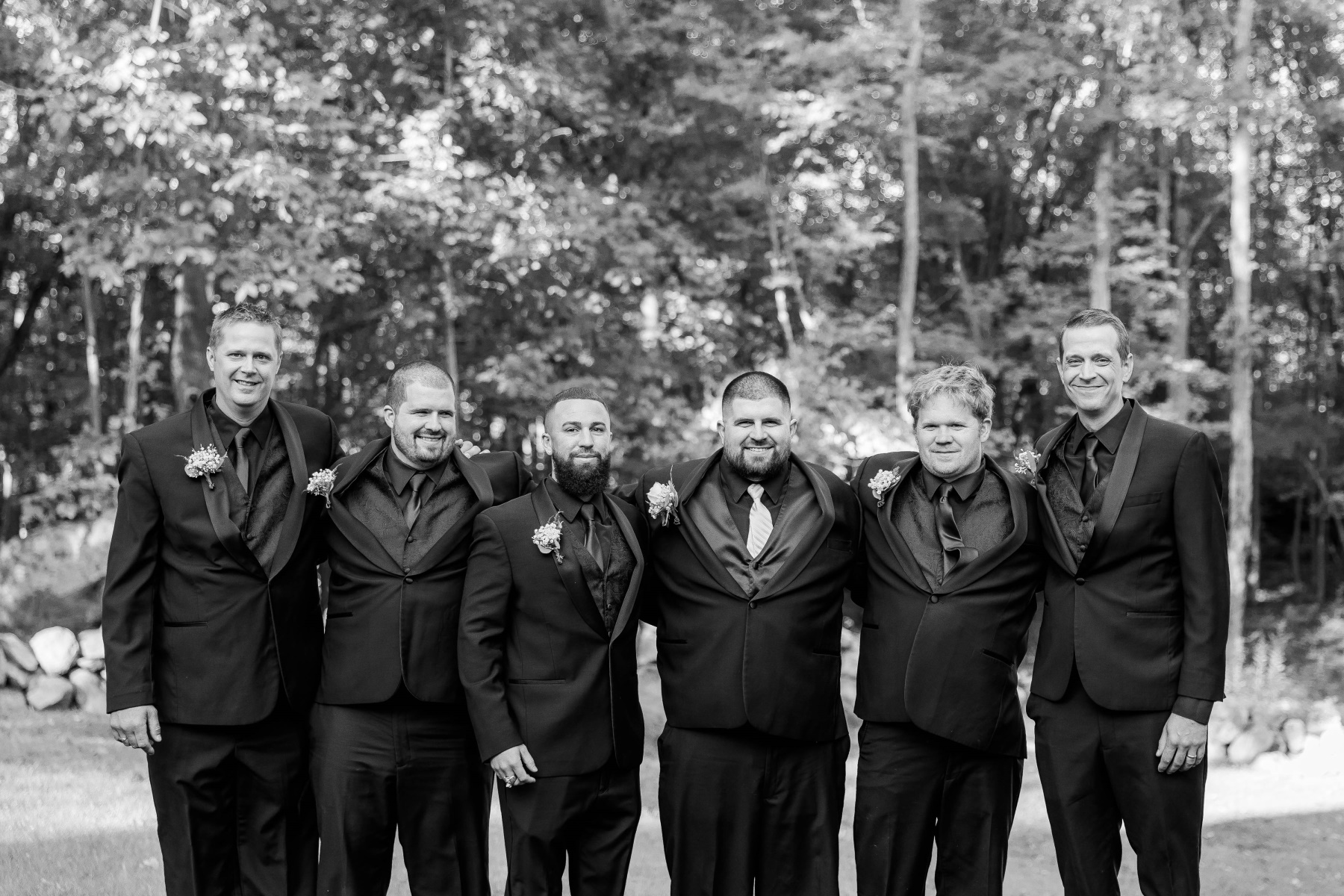 Groom and groomsmen smile at camera with arms around each other at Great Neck Country Club Wedding