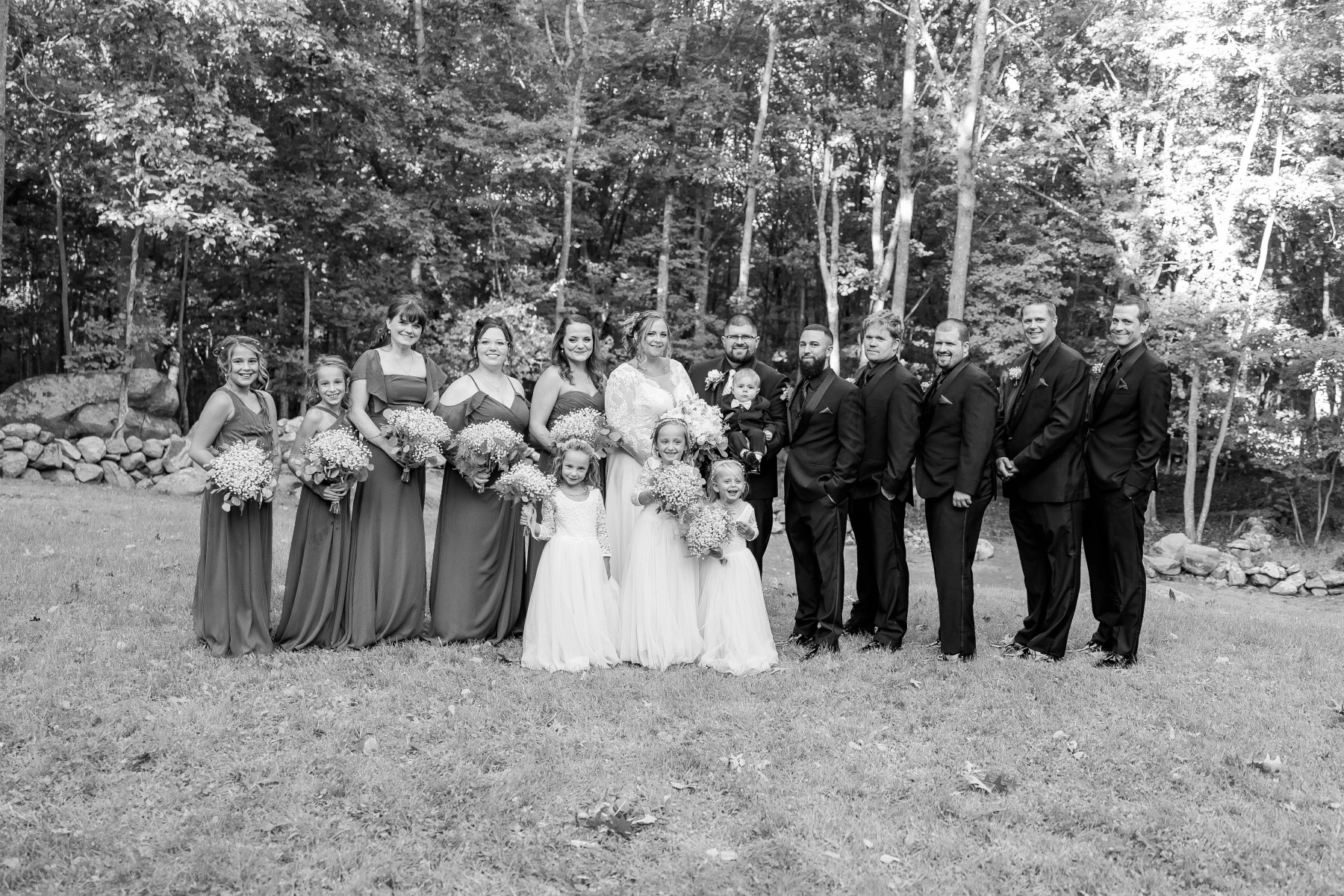 Bride and groom smile with their bridesmaids, groomsmen, flower girls, and ring bearer at Great Neck Country Club Wedding