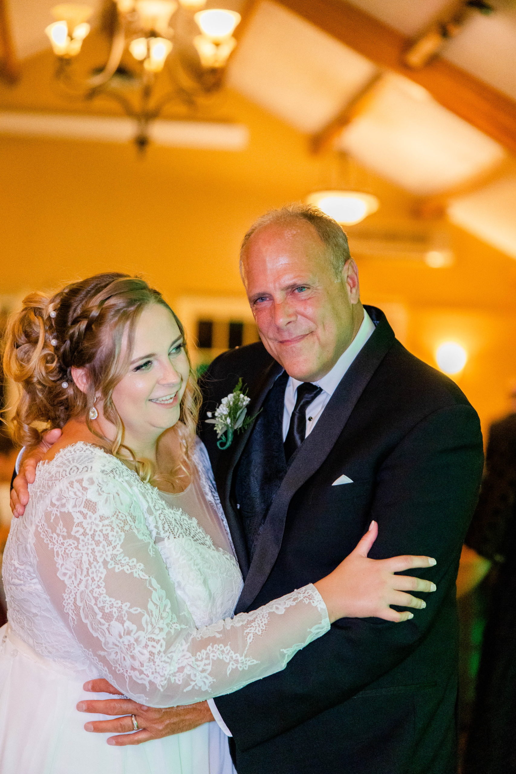 Father of bride smiles at camera while dancing with bride at Great Neck Country Club Wedding