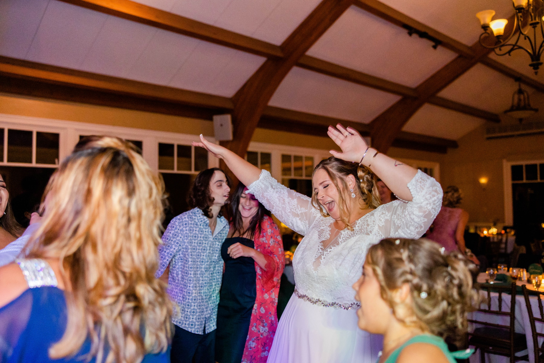 Bride gleefully dances with wedding guests at Great Neck Country Club Wedding